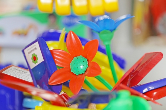Buntes Strandspielzeug aus Plastik, im Zentrum ist eine Rote Blume zu erkennen.
