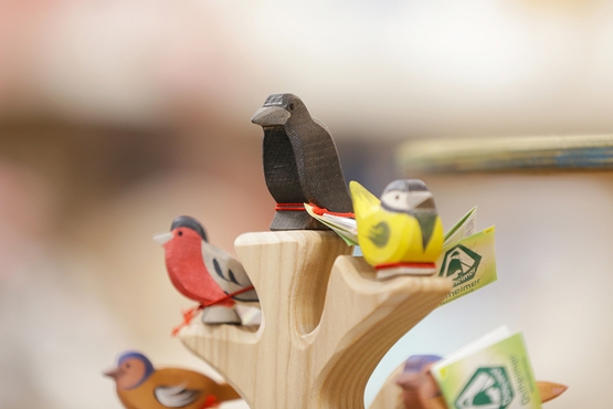Eine Detailaufnahme von kleinen, bunten Vögeln aus Holz.